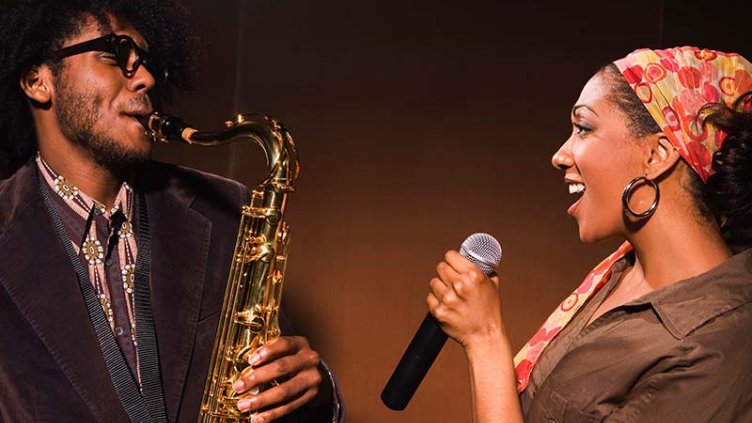 One person plays the saxophone and the other sings
