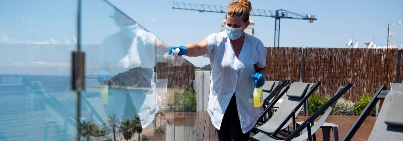 Lady cleaning the glasses on terrace